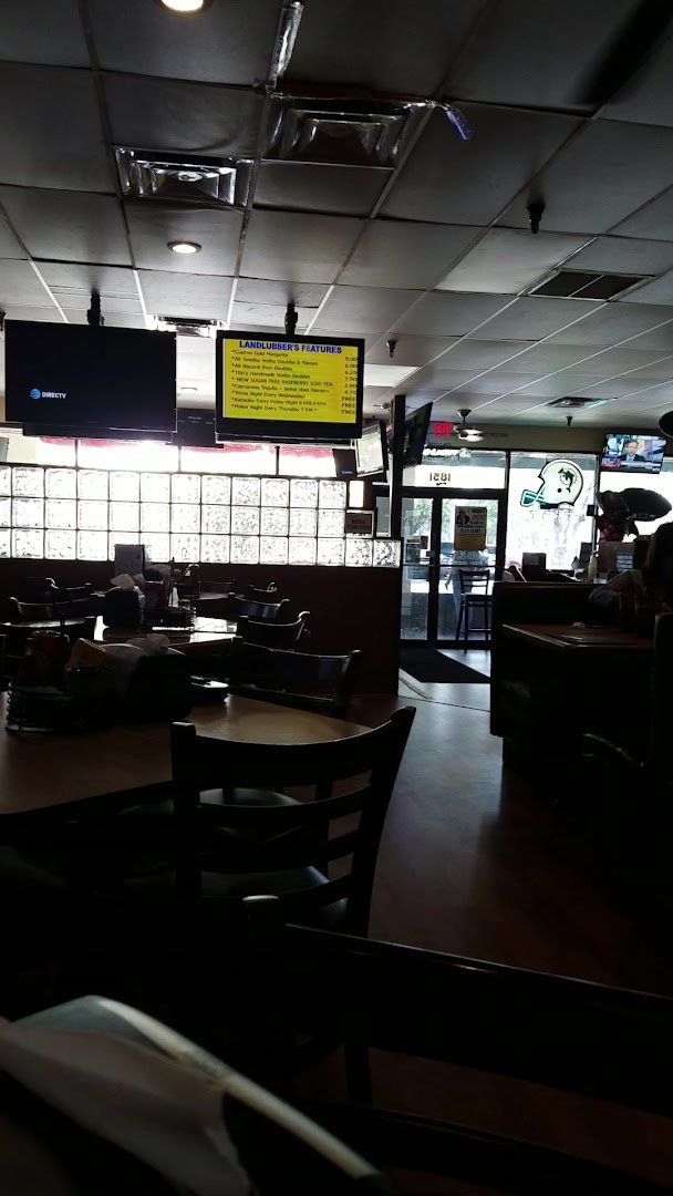 Sports bar tables beside wall-mounted televisions.